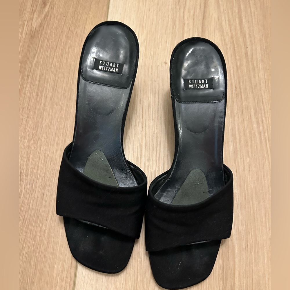 Stuart Weitzman black satin kitten heel slides.